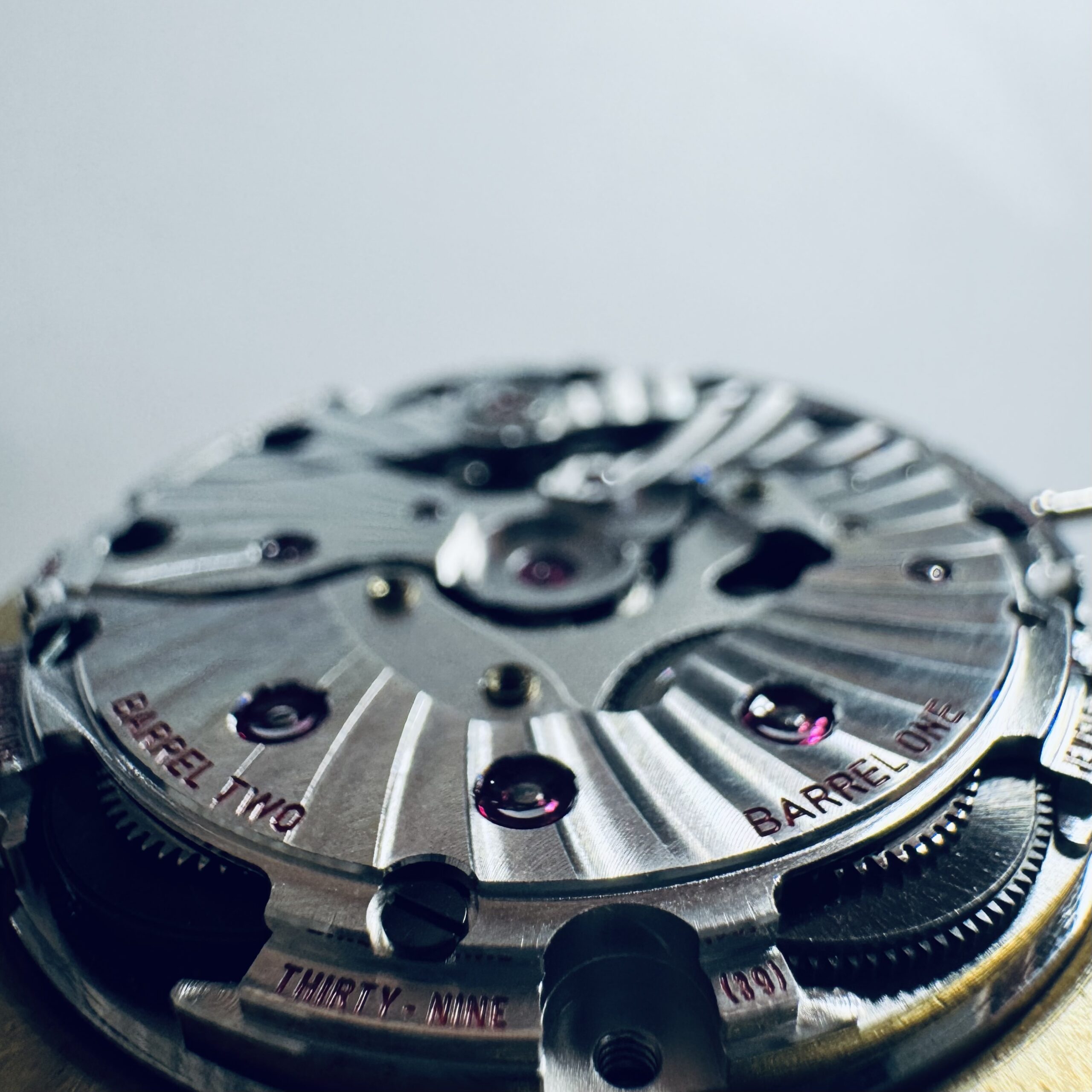 Omega Calibre 8500 Co-Axial — Barrel One en Barrel Two gravure, macro-opname